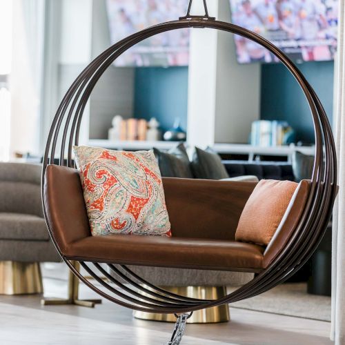 A cozy living room with a curved fireplace, a brown sofa, patterned throw pillows, a round coffee table, and a warm, inviting d&eacute;cor vibe.